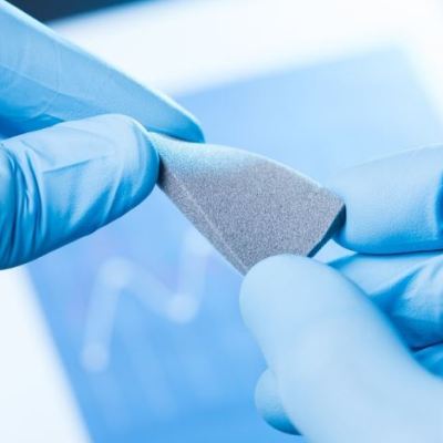 Plastic specimen undergoing tensile strength testing on universal testing machine