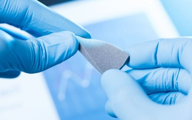 Plastic specimen undergoing tensile strength testing on universal testing machine