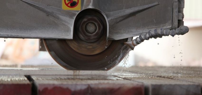 Taber abraser performing rotary abrasion test on coated surface specimen