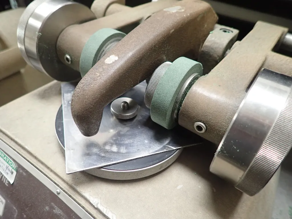 Metallographic abrasive saw cutting a steel alloy specimen
