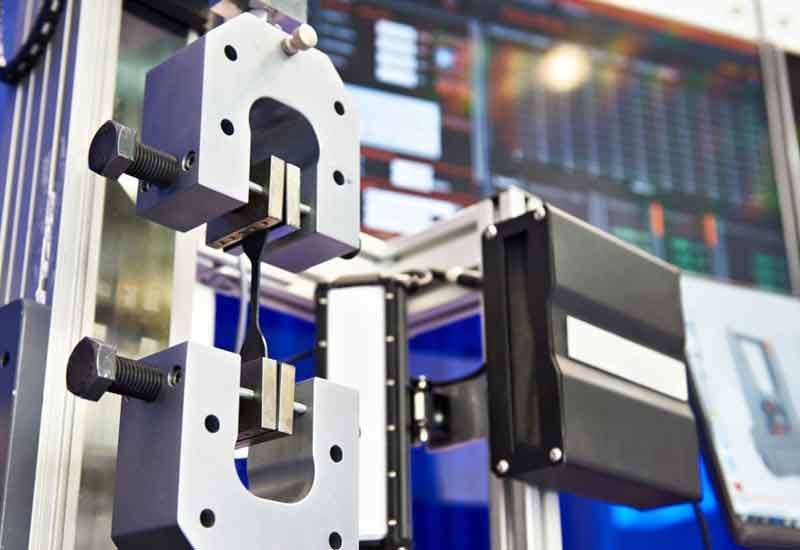 Vickers hardness tester with diamond indenter positioned over polished metal specimen