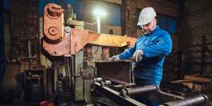 Manufacturing quality inspector reviewing metal test certificates for tensile and hardness results