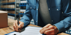 Quality control inspector reviewing test report data for metal component acceptance criteria